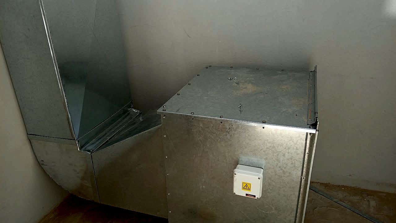 Caja de ventilación de chapa galvanizada con un codo de ducto, instalada en obra, con una caja de conexión eléctrica