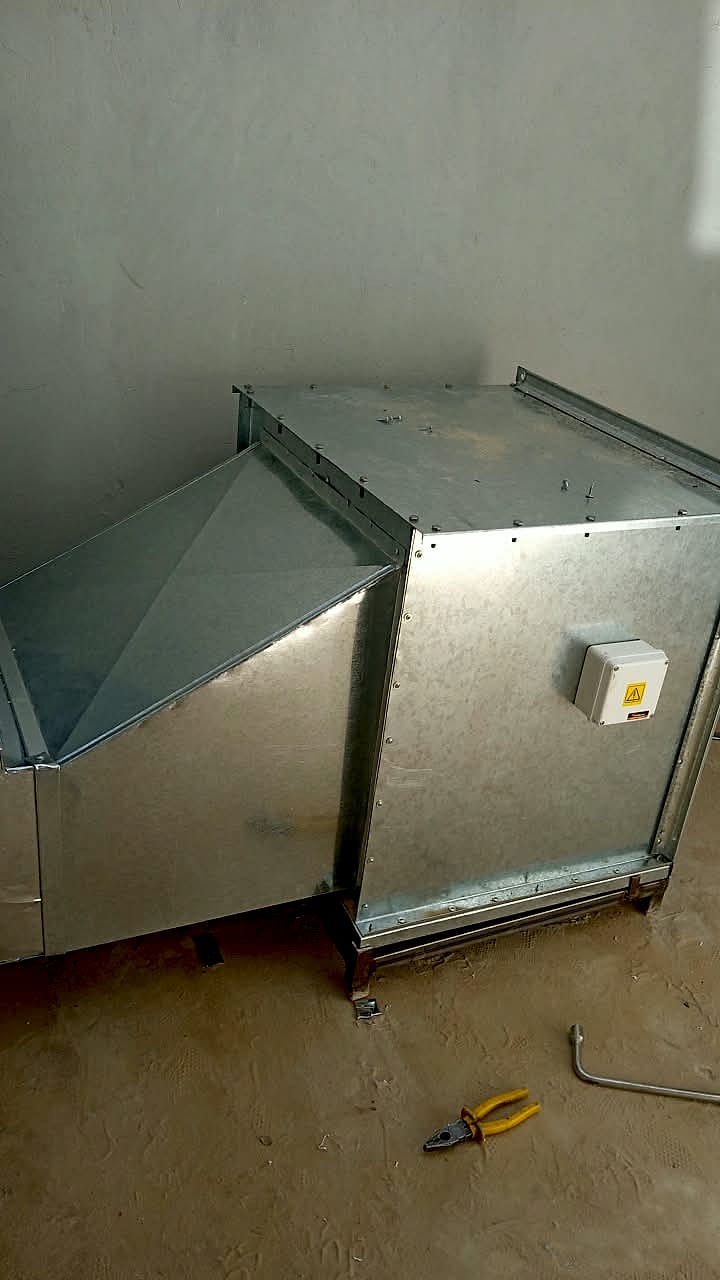Caja de ventilación de chapa galvanizada con la transición del ducto, sobre una bancada